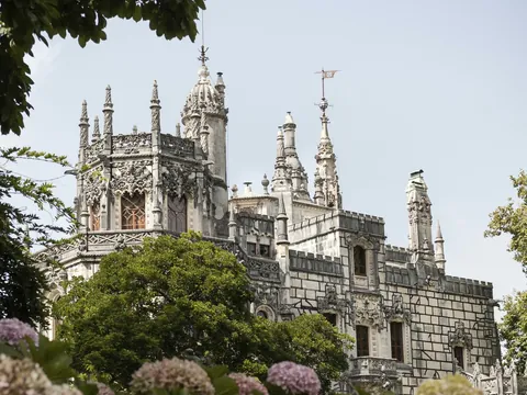 Fachada de la Quinta da Regaleira entre hortensias en Sintra, Portugal.