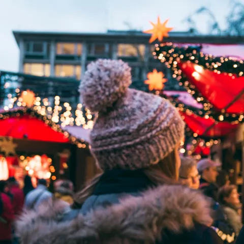 Niña en un mercadillo de Navidad - Los mejores destinos de Europa en el puente de diciembre 2022 - Blog - Buendía Tours