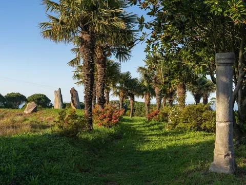 Jardines de Fonte Baxa con palmeras y restos históricos en Luarca, Asturias