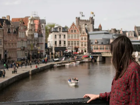 Mujer observando el canal desde un puente en Gante, Bélgica