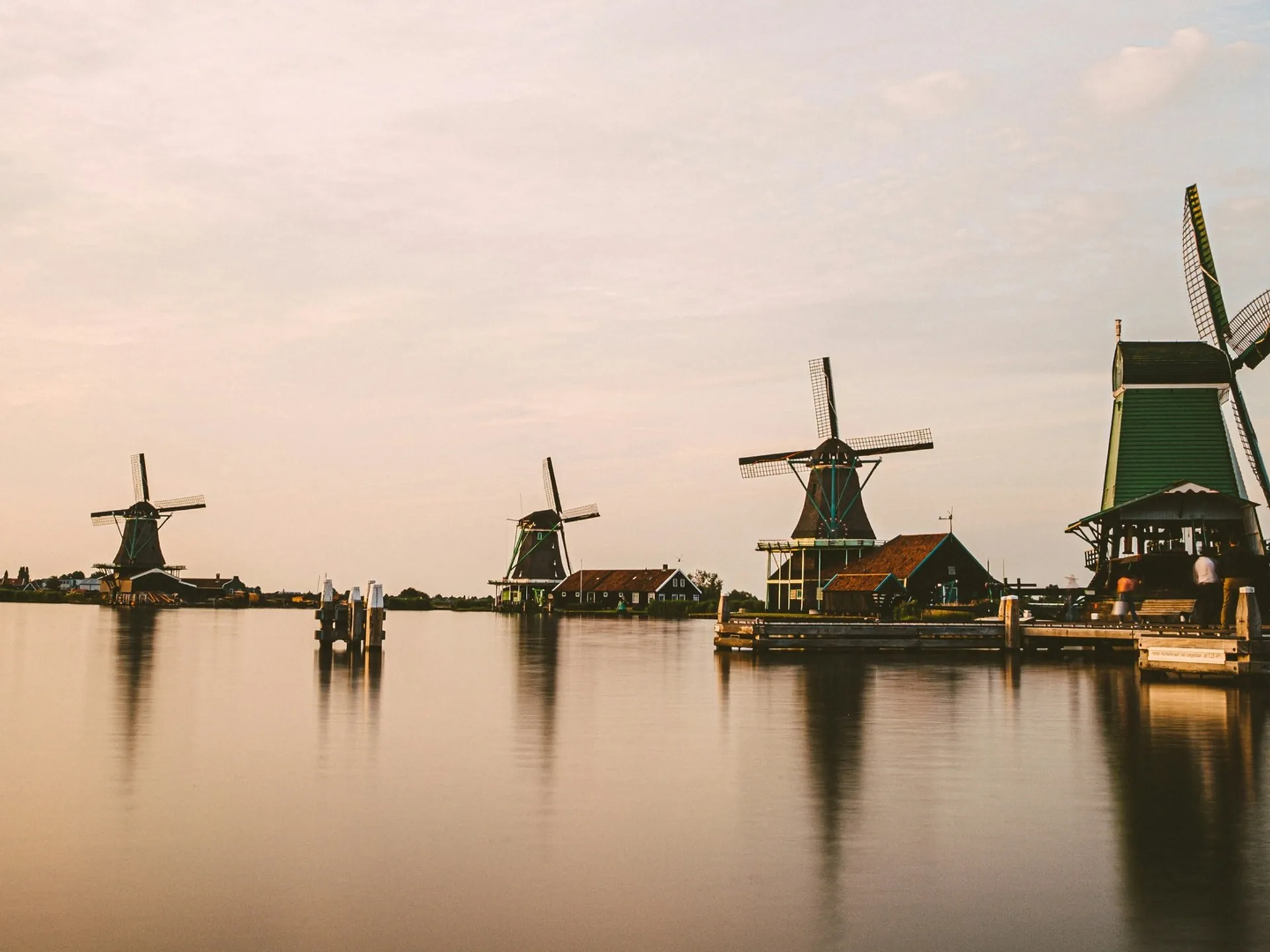 Molinos de viento de Zaanse Schans reflejados en el agua durante el atardecer. 