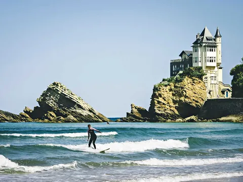 Surfista en la playa frente a Villa Belza en Biarritz, costa francesa