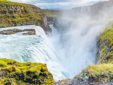 Catarata Gullfoss en Islandia, una de las más impresionantes del Círculo Dorado, rodeada de verdes acantilados.