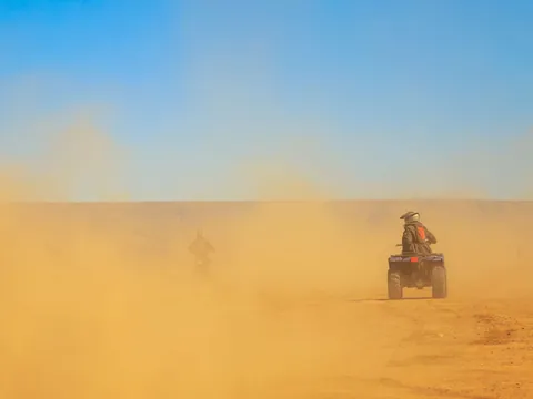 Quad levantando polvo a toda velocidad en el Palmeral de Marrakech