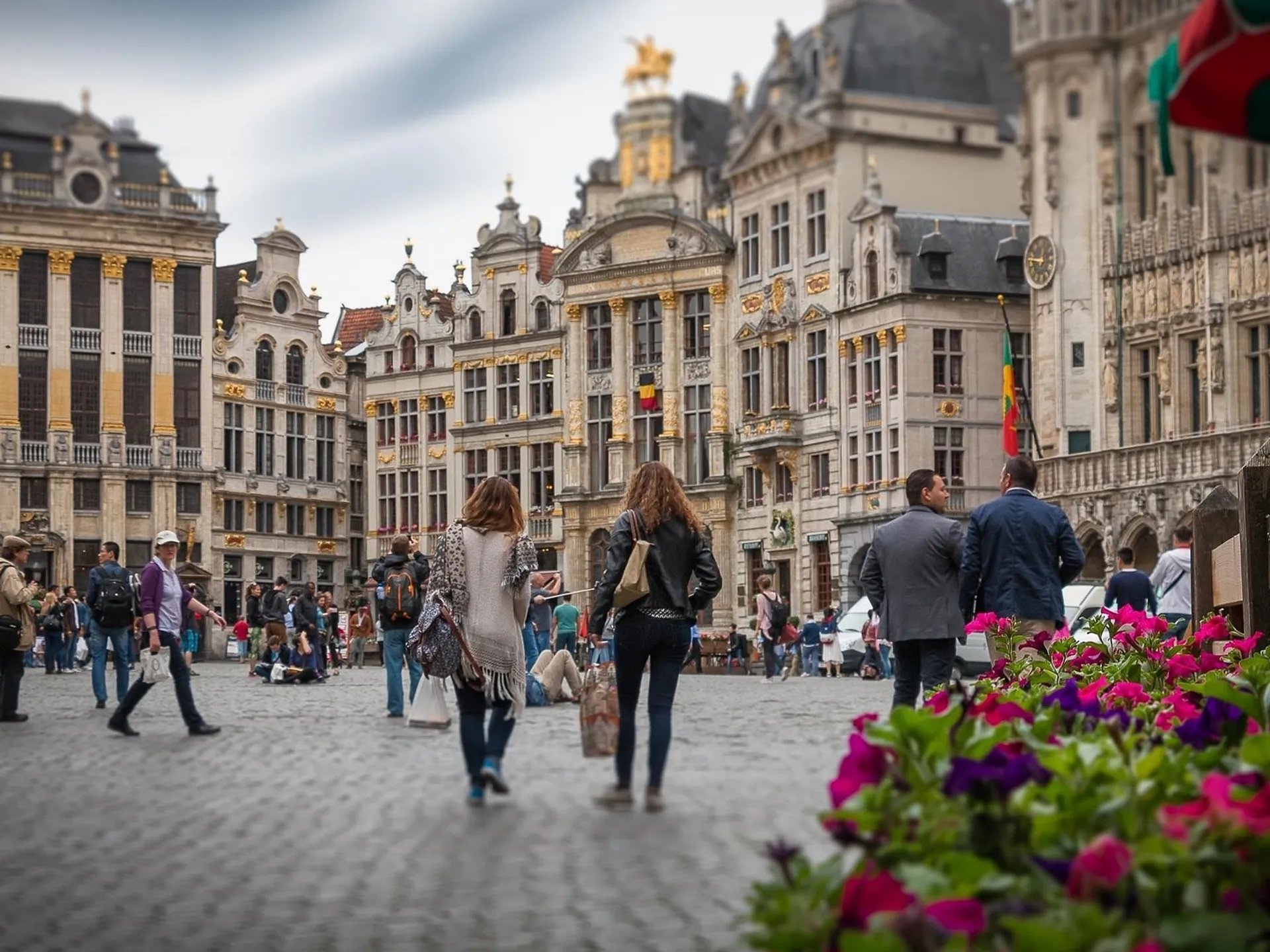 Turistas paseando por la Grand Place de Bruselas rodeada de edificios barrocos.