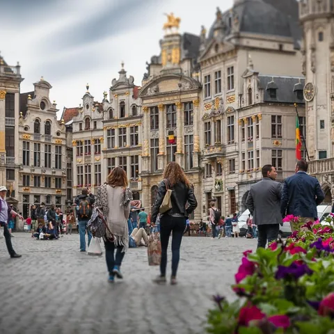 Turistas paseando por la Grand Place de Bruselas rodeada de edificios barrocos.