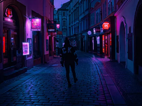 Callejón nocturno iluminado por neones en Praga, República Checa
