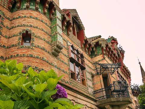 Fachada modernista de El Capricho de Gaudí en Comillas, Cantabria, con detalles cerámicos y flores.