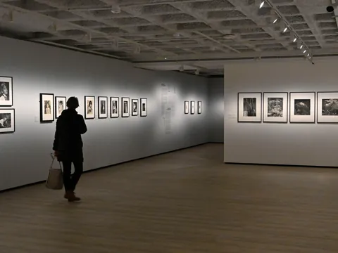 Persona observando exposición de Ilse Bing en el centro KBR