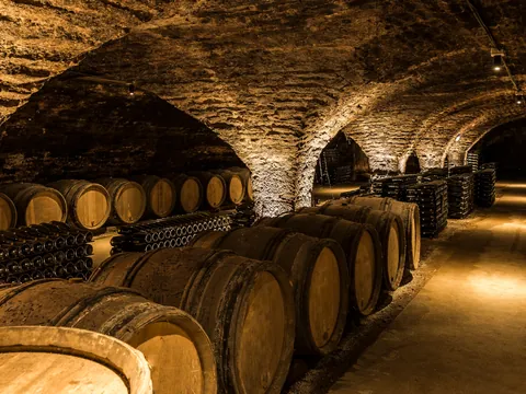 odega subterránea con barricas de vino y botellas apiladas