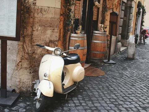 Vespa clásica aparcada en una calle empedrada de Roma