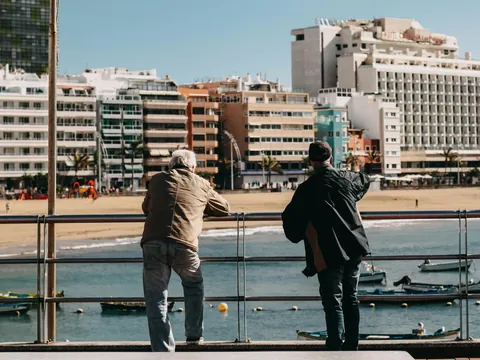 Personas mirando el mar y barcas en la Playa de Las Canteras, Las Palmas.