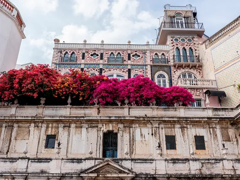 Fachada con flores y azulejos del Chafariz d'El Rei en el barrio de Alfama, Lisboa