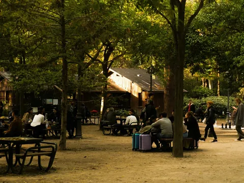 Personas jugando al ajedrez en una zona arbolada del Retiro, Madrid.