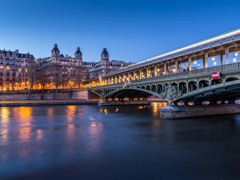 Puente de Bir-Hakeim iluminado sobre el río Sena al atardecer en París.