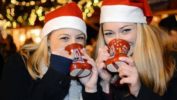 Chicas bebiendo en copas navideñas en el mercado de Aachen