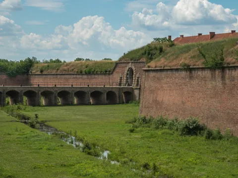 Muros de ladrillo y un puente con arco sobre un foso en la Fortaleza de Terezín.