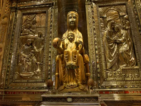 La Moreneta, patrona de Cataluña, estatua de la Virgen de Montserrat en oro, rodeada de relieves metálicos.