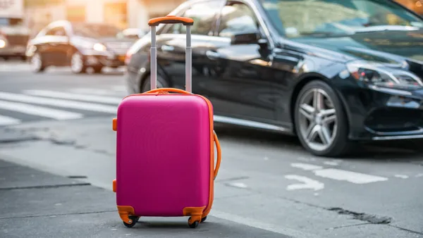 Maleta de viaje moderna con diseño elegante y ruedas giratorias sobre superficie lisa.
