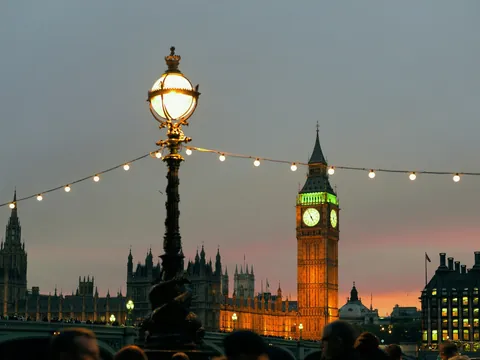 Big Ben iluminado tras farolas y guirnaldas de luces junto al Támesis.