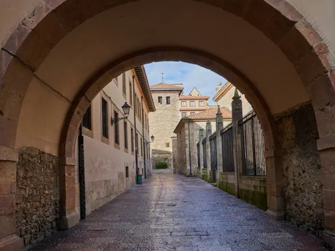 Pasadizo con arco de piedra en el casco antiguo de Oviedo, que conduce a las callejuelas históricas de la capital asturiana.