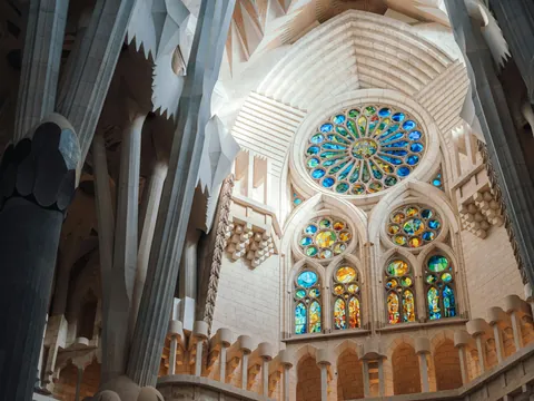 Interior de la Sagrada Familia en Barcelona con vitrales de colores y columnas monumentales