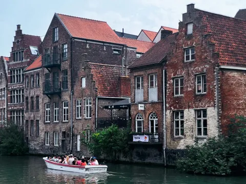 Barco con turistas navegando por los canales de Gante