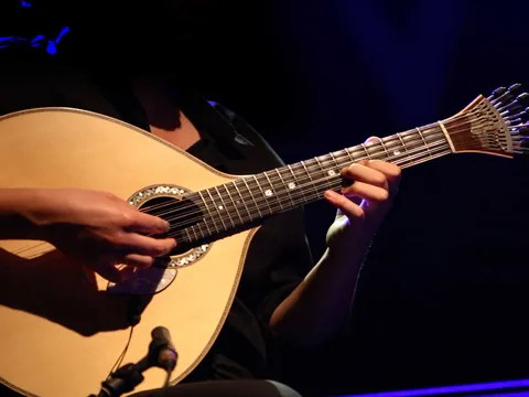 Guitarra portuguesa sonando en un espectáculo de fado en Lisboa