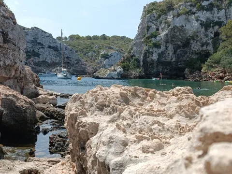 Veleros y kayaks en una cala de Menorca, Baleares