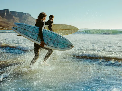 Surfistas entrando al mar en la playa de San Antolín, Llanes, Asturias