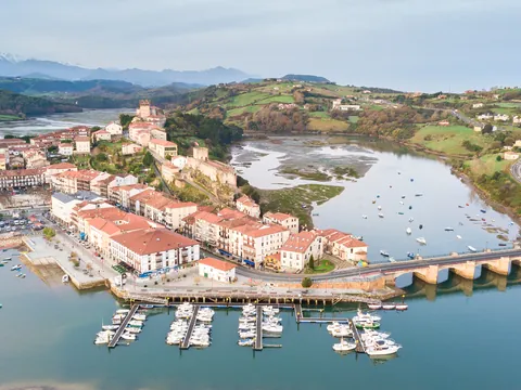 Vista aérea de San Vicente de la Barquera con su puerto y los Picos de Europa