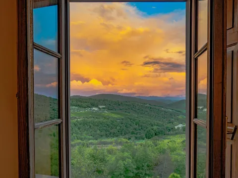 Atardecer sobre las colinas de la Toscana visto desde una ventana