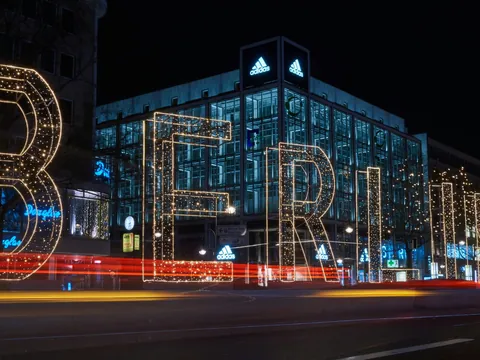 Letrero luminoso gigante de BERLÍN en una calle nocturna con estelas de coches.