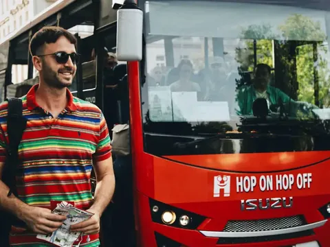 Un turista sonriendo sube a un autobús Hop-on Hop-off en Praga.