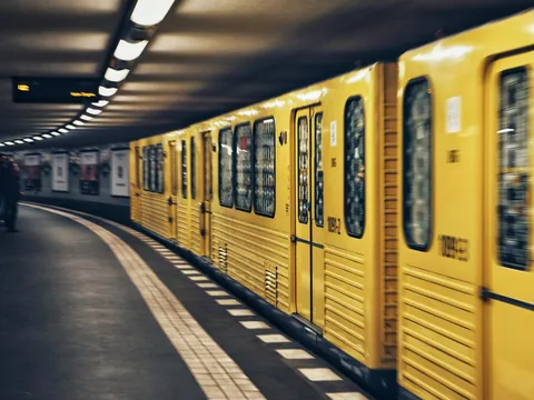 Tren amarillo del U-Bahn de Berlín llegando a una estación subterránea curva.