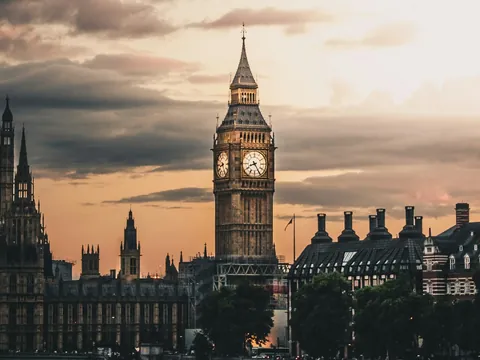 Torre del Big Ben y Palacio de Westminster bajo un cielo nublado al atardecer.