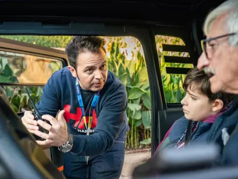 Guía turístico explicando el uso del walkie-talkie tour vehículo eléctrico cuevas del tesoro, málaga, españa