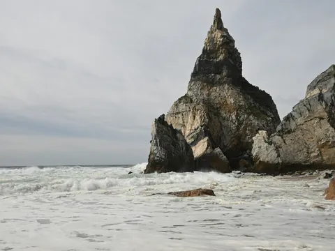 Acantilados y rocas puntiagudas en una playa con fuerte oleaje en Cabo da Roca.