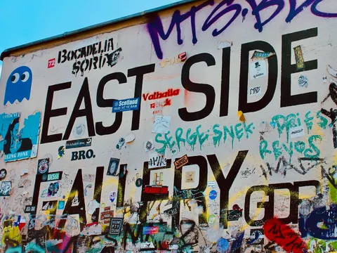 Detalle del muro de la East Side Gallery de Berlín cubierto de grafitis y pegatinas