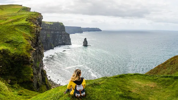 Mujer observando los Acantilados de Moher en Irlanda