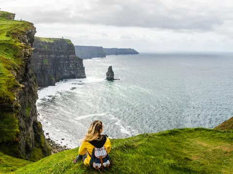 Mujer observando los Acantilados de Moher en Irlanda