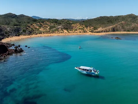 Vista panorámica del barco frente a la playa de Cavalleria, norte de Menorca